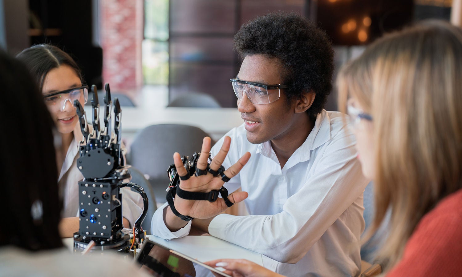 A group of people sitting at a table demoing a new technology 